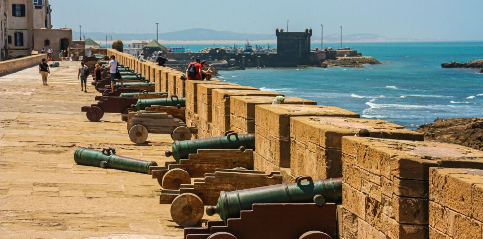Cannons on a fortress wall facing the sea, capturing historical and coastal scenery.